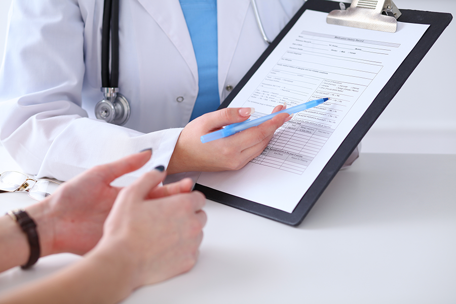 A doctor reviews an insurance form with a patient, discussing drug and alcohol treatment options.