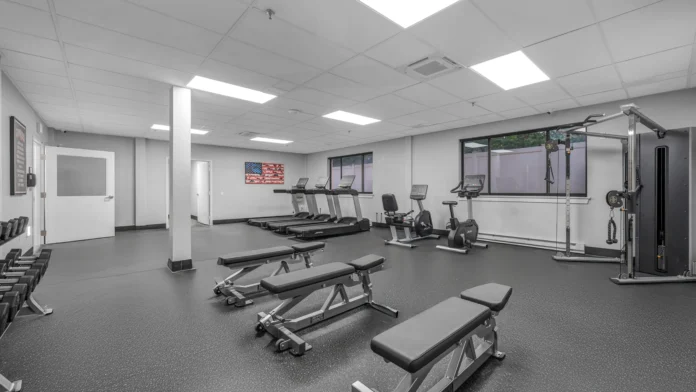 Weight training area with dumbbells and benches in Boca Recovery Center Springfield, MA fitness center.