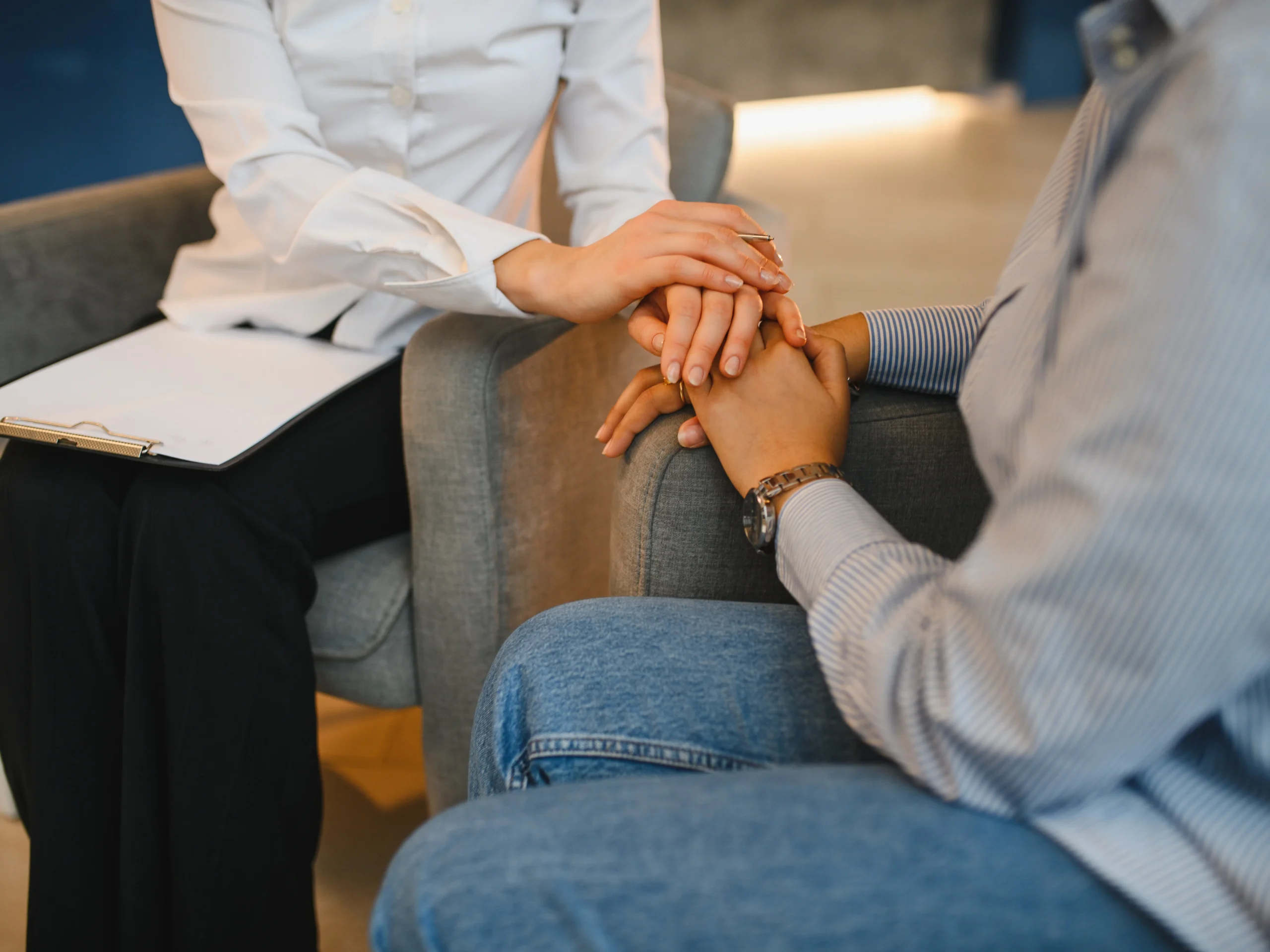 Therapist gently holding a patient’s hands during a counseling session about Xanax addiction support.